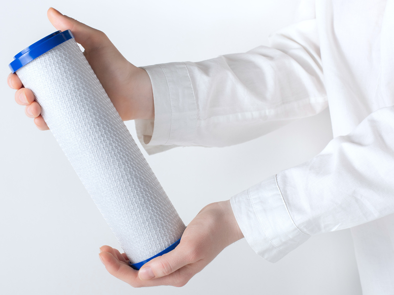 A person holding a water filter cartridge
