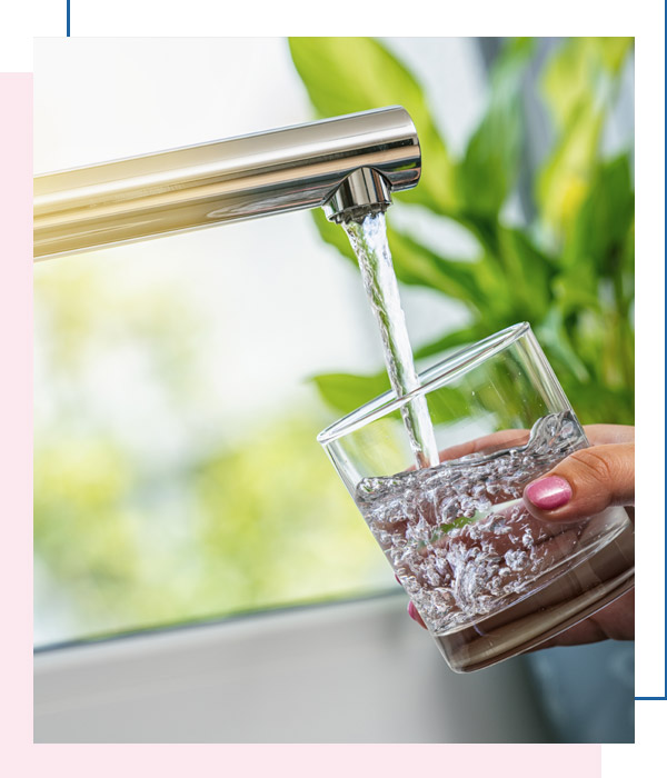 Drinking glass under running water faucet