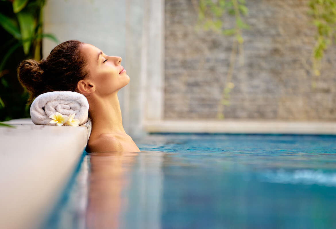 A woman is relaxing in a filtered spa water pool