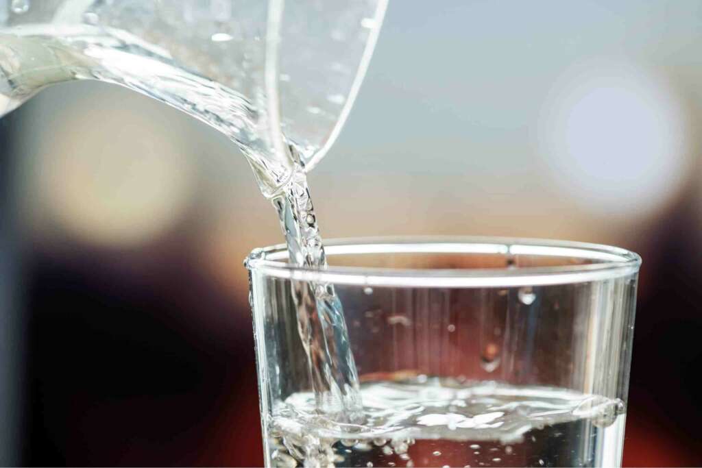 Pitcher pouring into glass of water