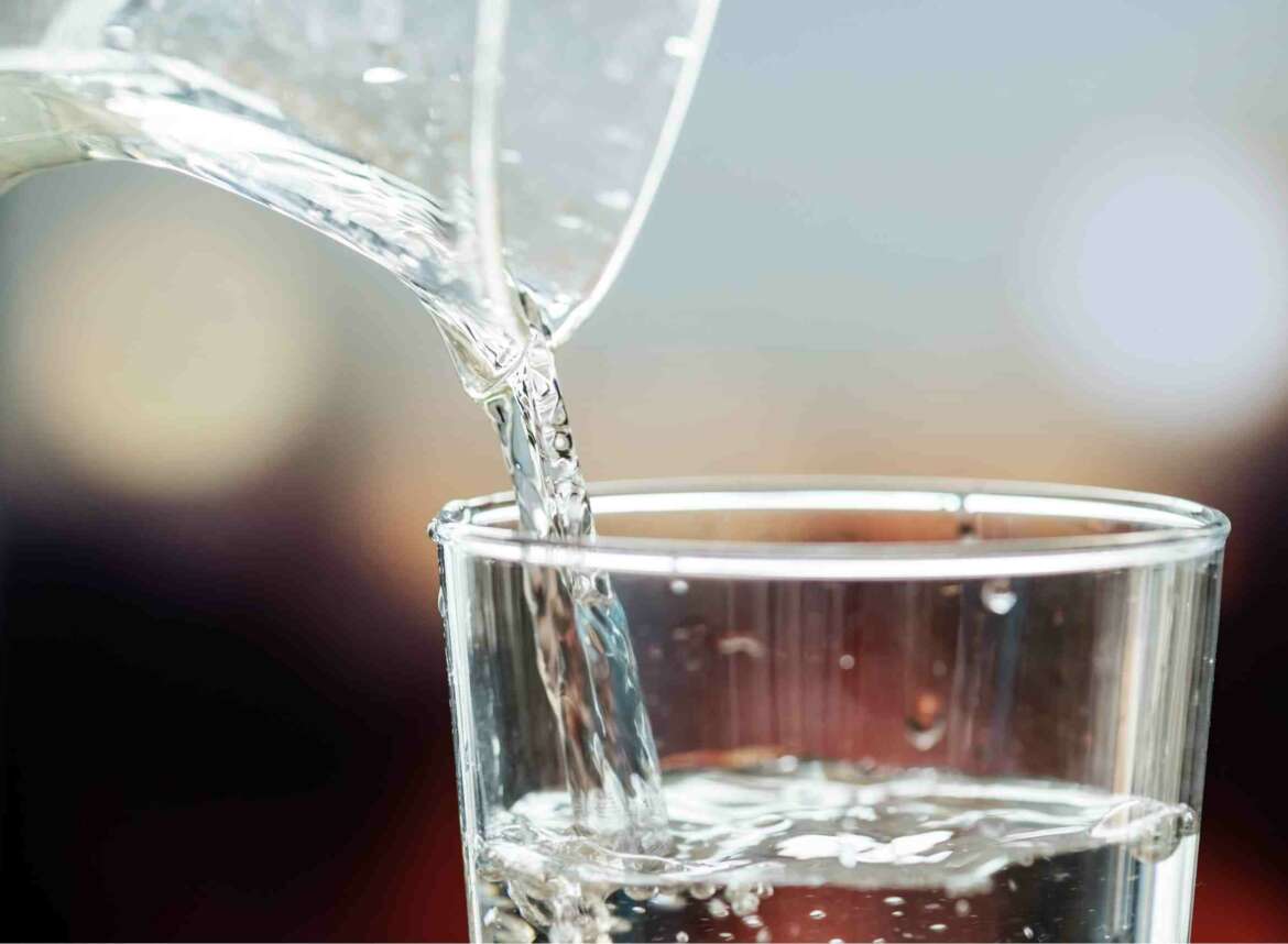 Pitcher pouring into glass of water