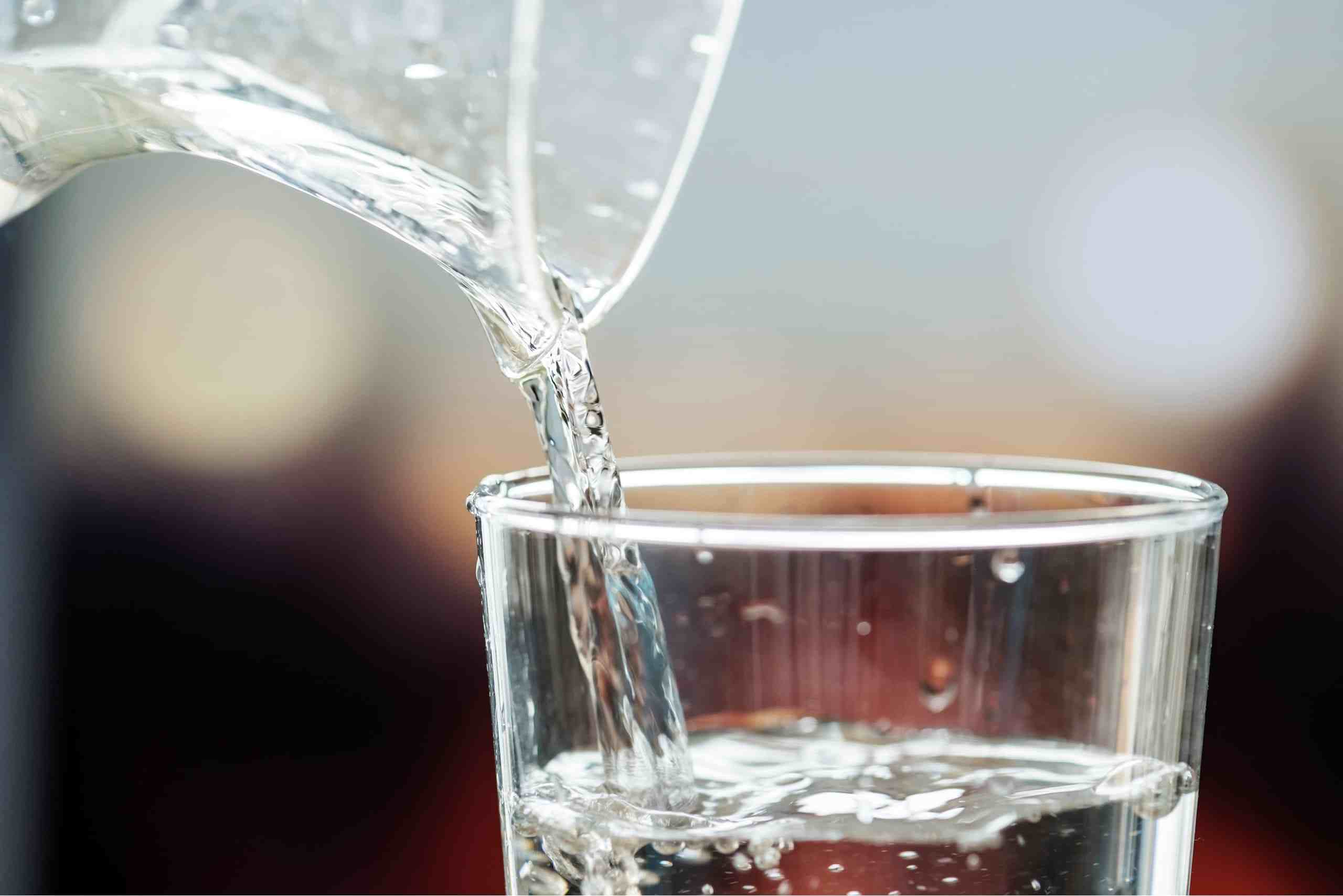 Pitcher pouring into glass of water