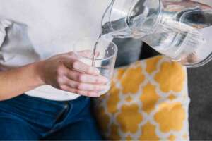 A person pouring water in a glass