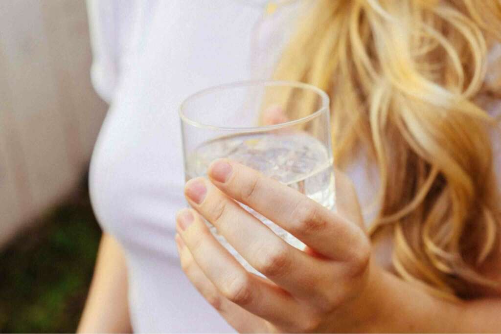 A woman holding a glass of water