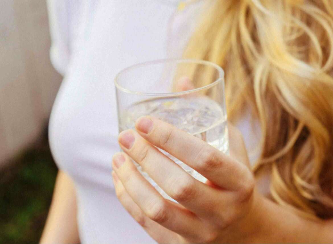 A woman holding a glass of water