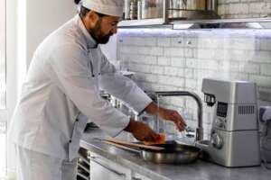 A chef using filtered tap water in the kitchen sink