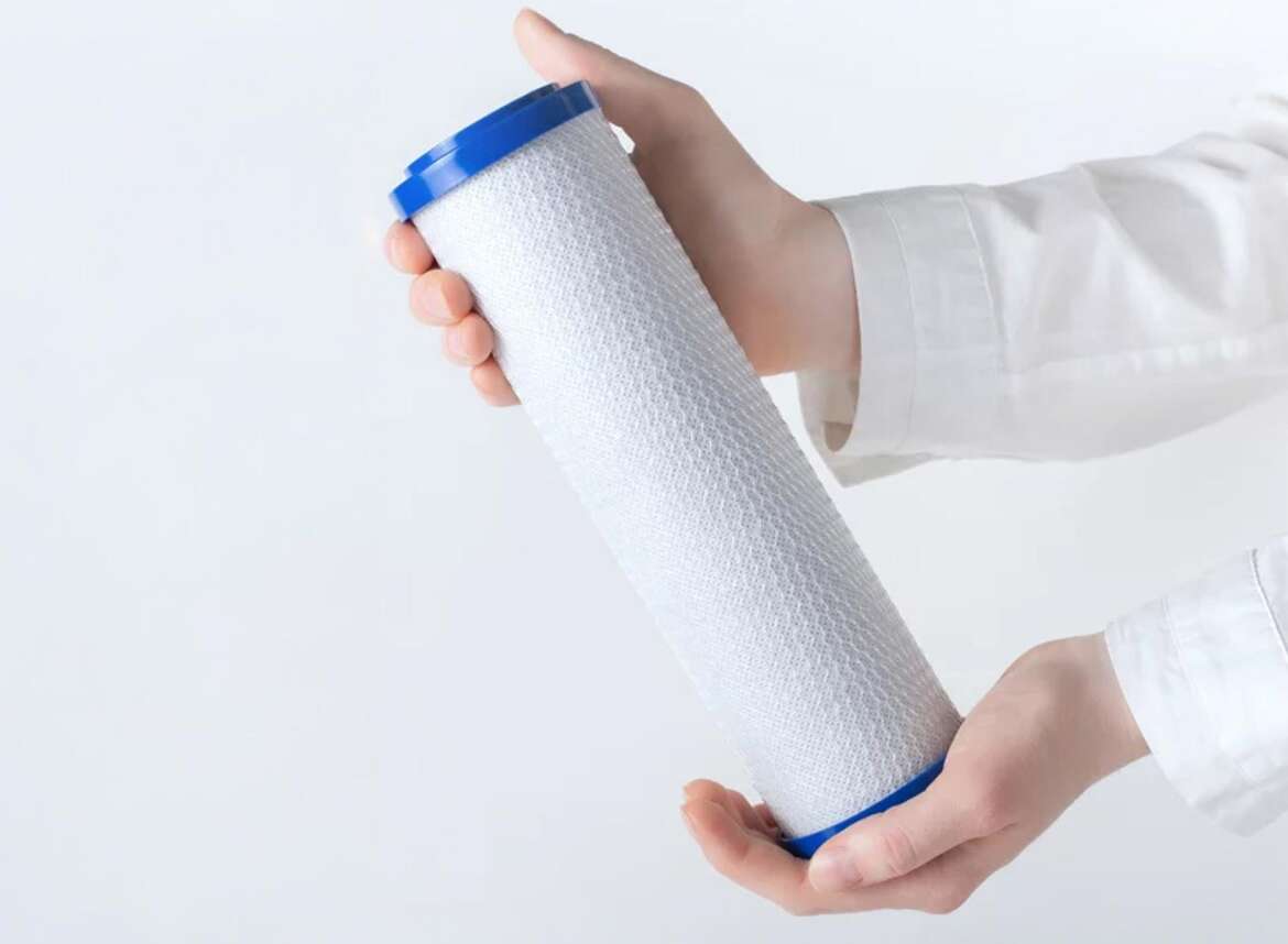 A person holding a carbon water filter cartridge