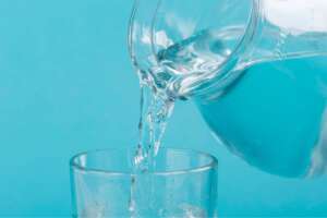 Iron-free water being poured from a pitcher into a glass