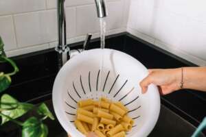 Washing cooked rigatoni pasta using chlorine-filtered tap water