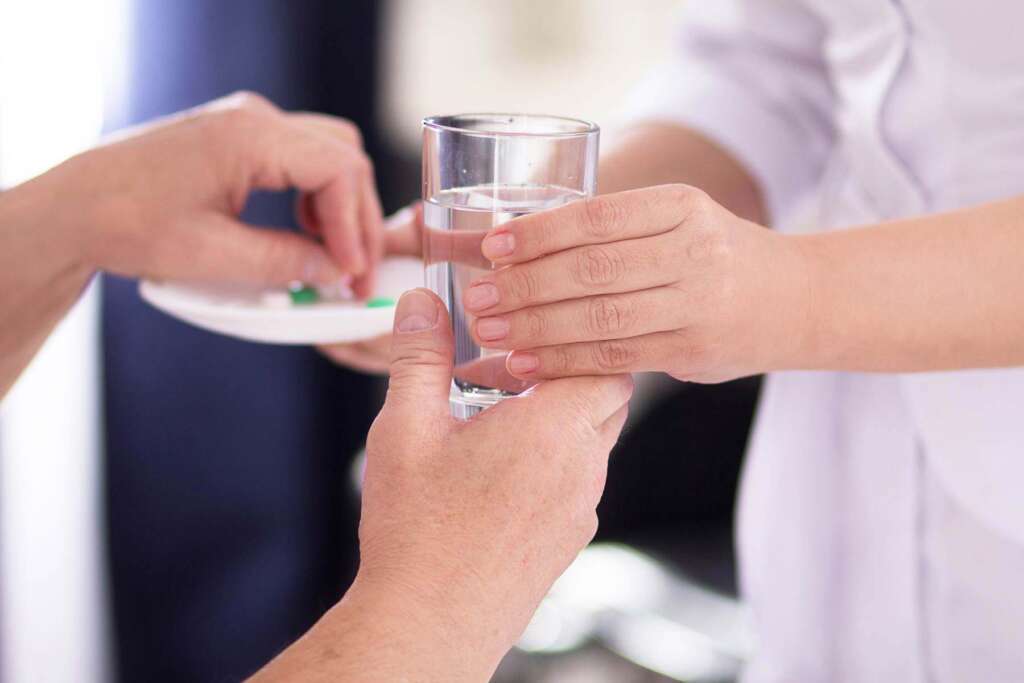 A nurse giving medicines to a patient