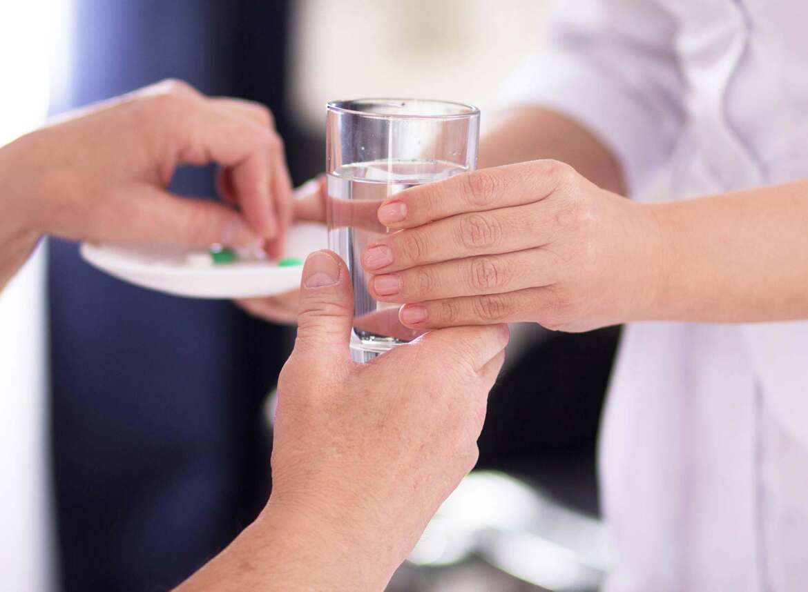 A nurse giving medicines to a patient