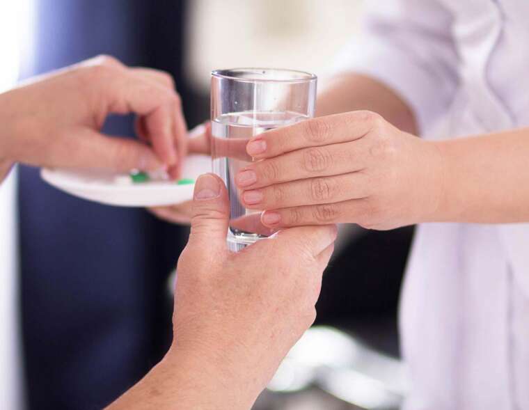 A nurse giving medicines to a patient