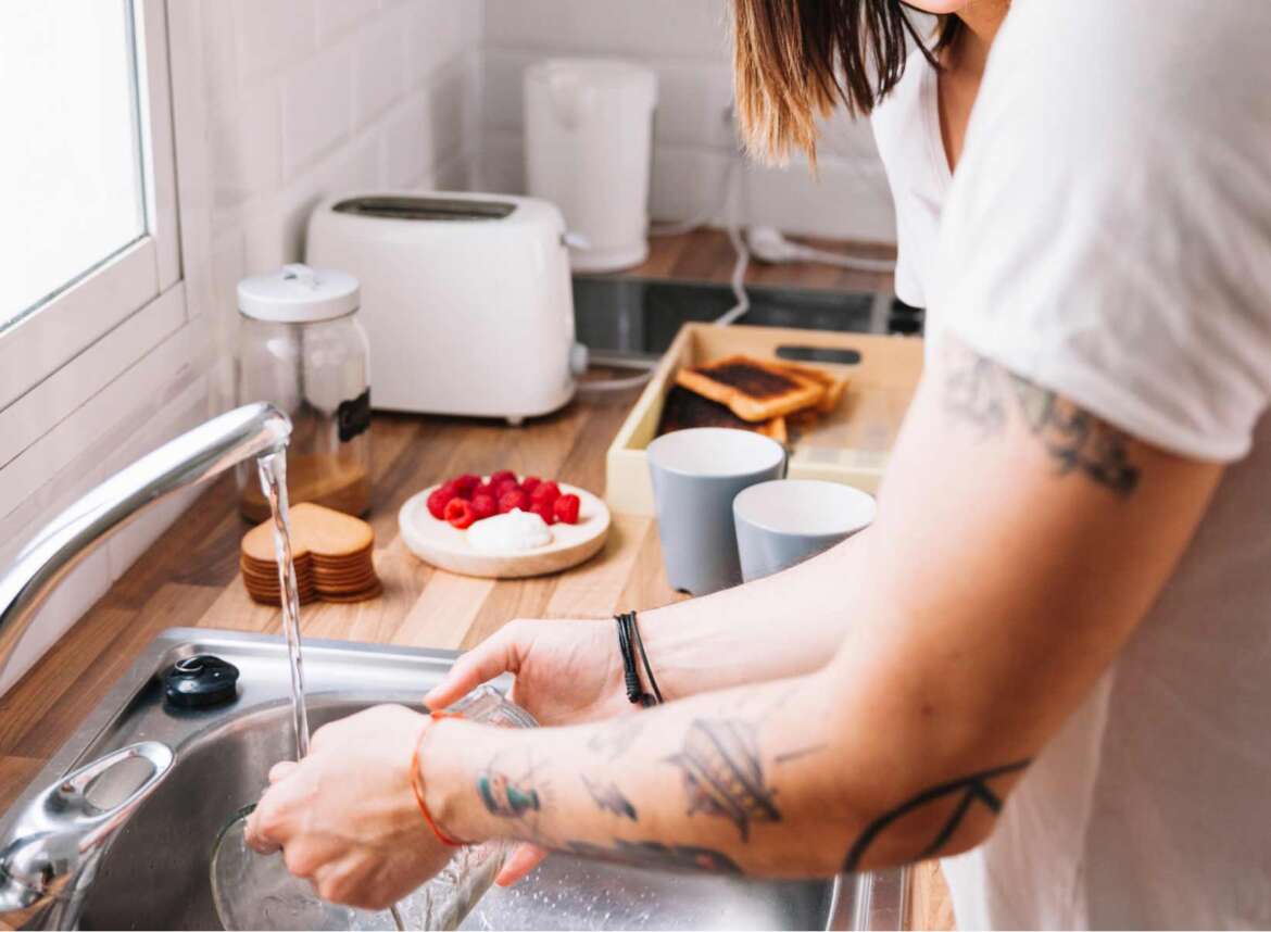 A woman washing in the kitchen sink using water filtered by a UV water filter