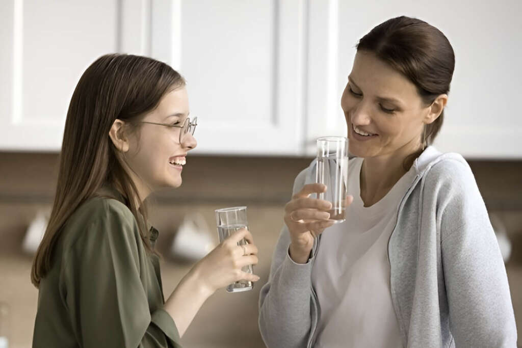 Two women engage in conversation, savoring their filtered water