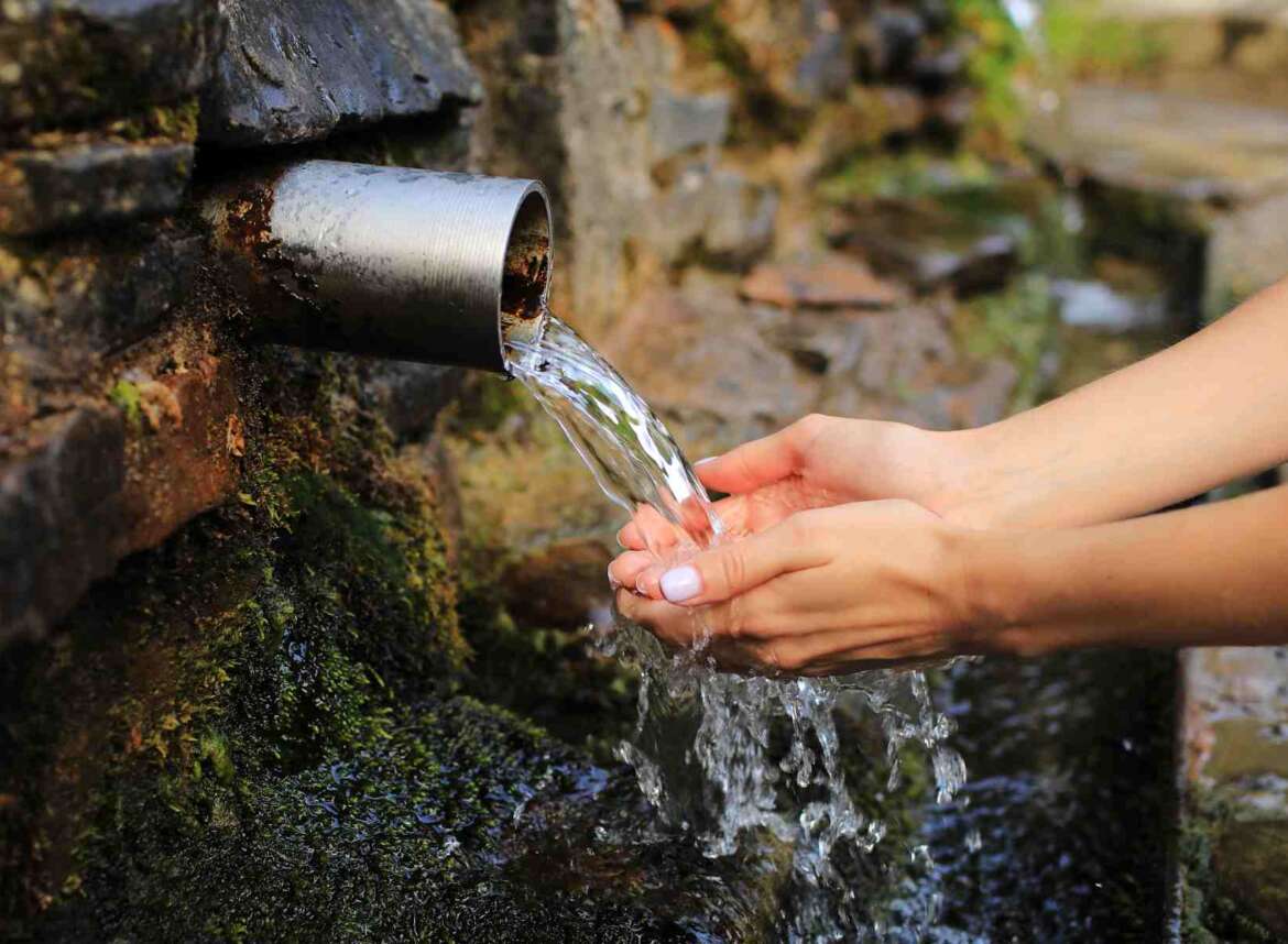 A hand scooping flowing water