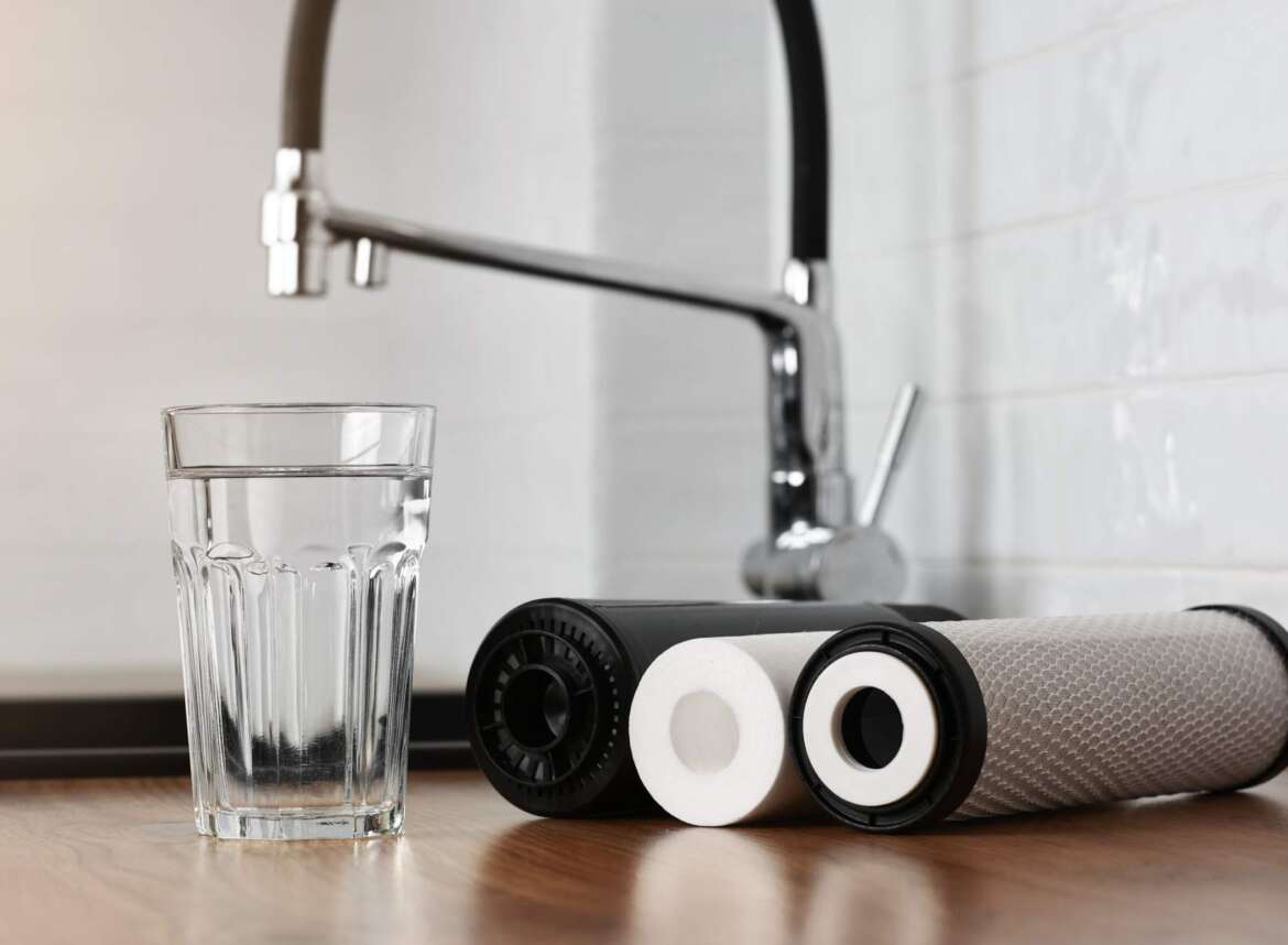 Water filter replacement and a glass of filtered water in the kitchen