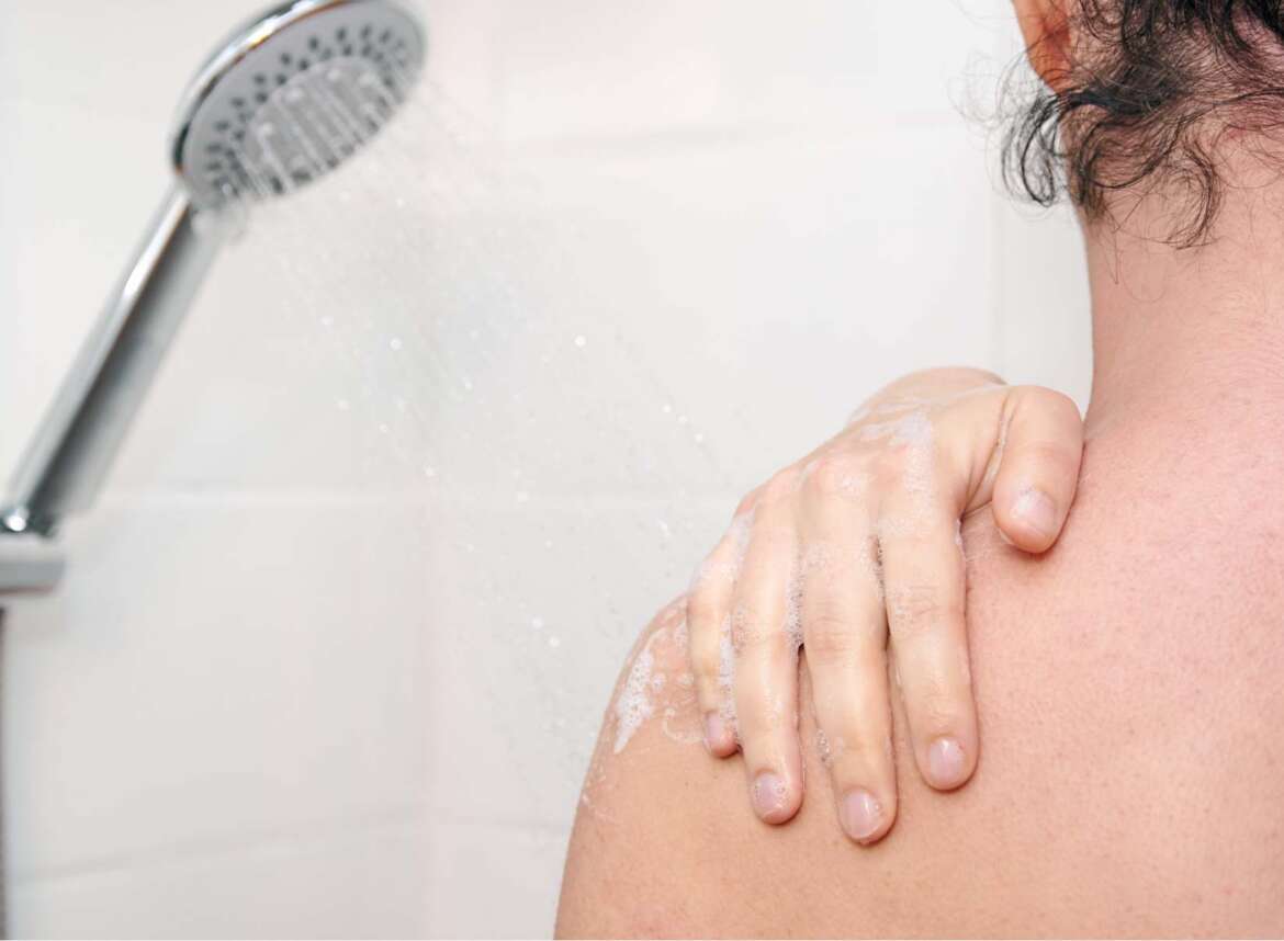 Woman standing with her back visible while showering