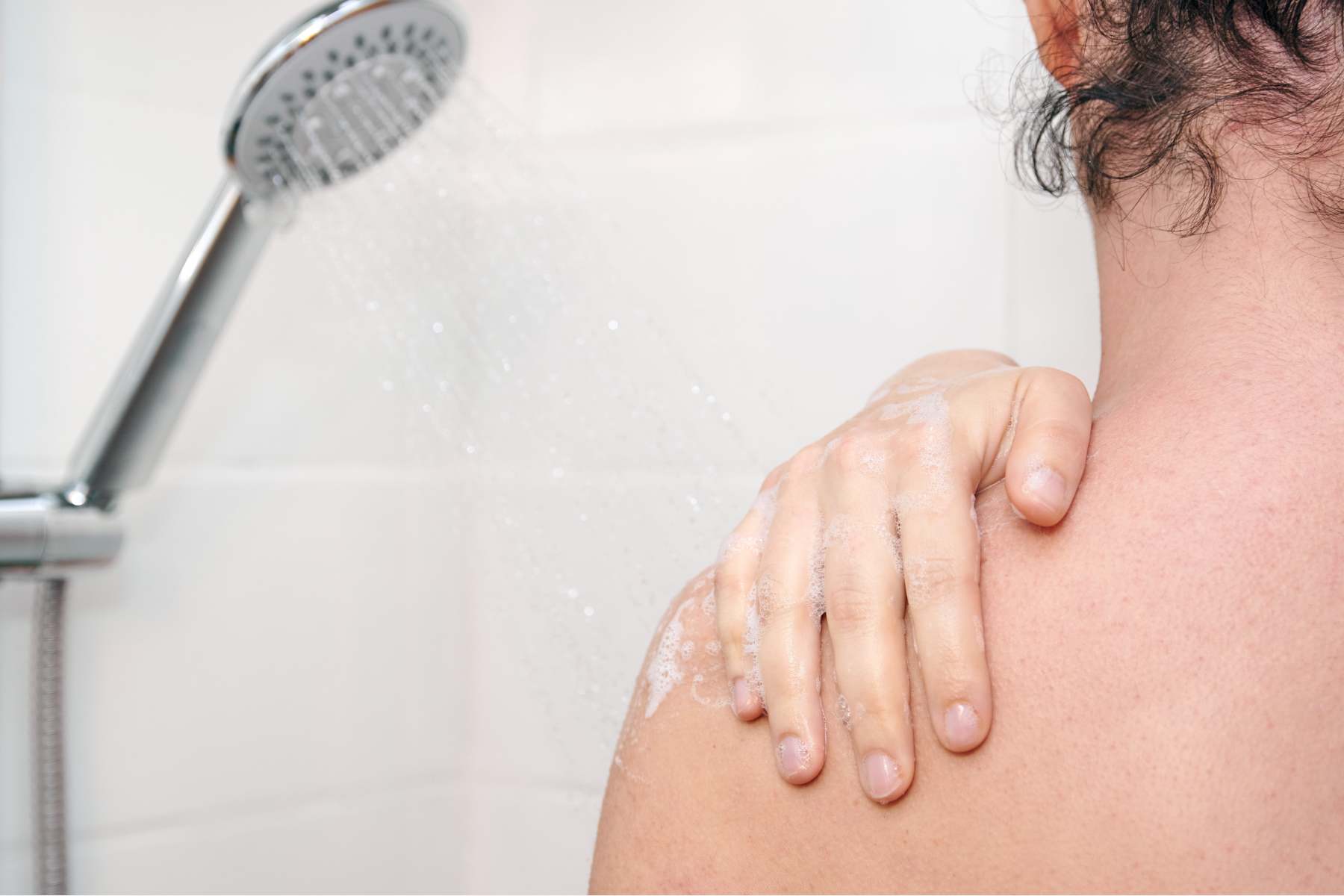 Woman standing with her back visible while showering